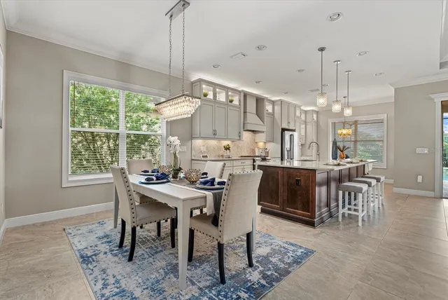 a view of a dining room and livingroom with furniture wooden floor a chandelier