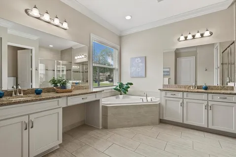 a large white kitchen with a sink and dishwasher with white cabinets
