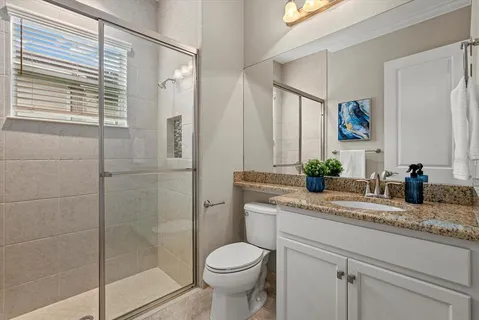 a bathroom with a granite countertop sink toilet and shower