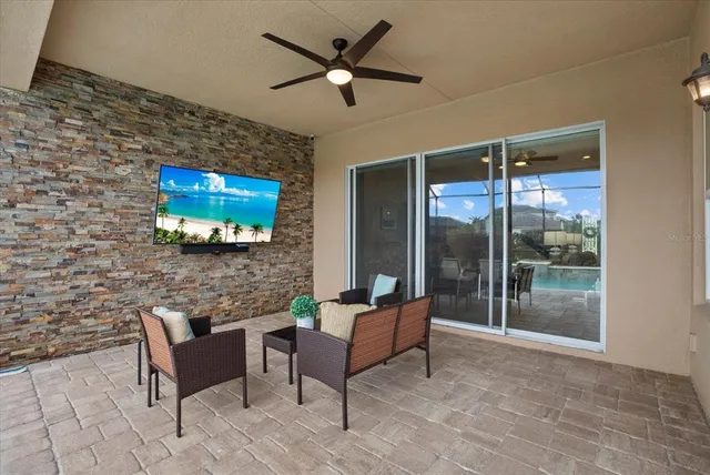 a living room with furniture a flat screen tv and a glass door