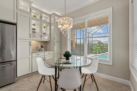 a dining room filled chandelier and wooden floor