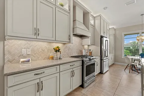 a kitchen with stainless steel appliances granite countertop a sink a stove and a refrigerator