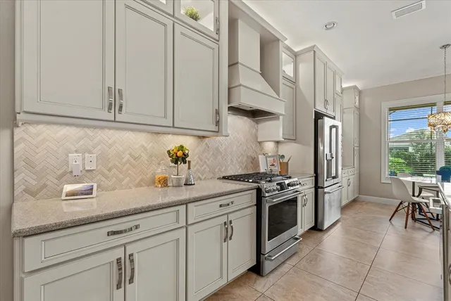 a kitchen with stainless steel appliances granite countertop a sink a stove and a refrigerator