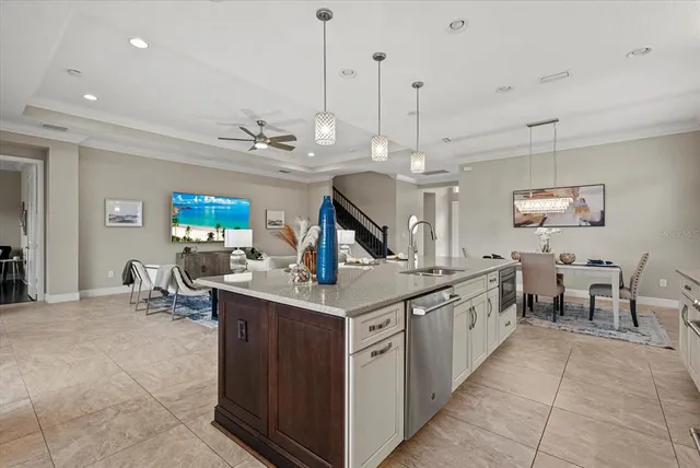 a kitchen with stainless steel appliances granite countertop a sink counter space and a view of living room