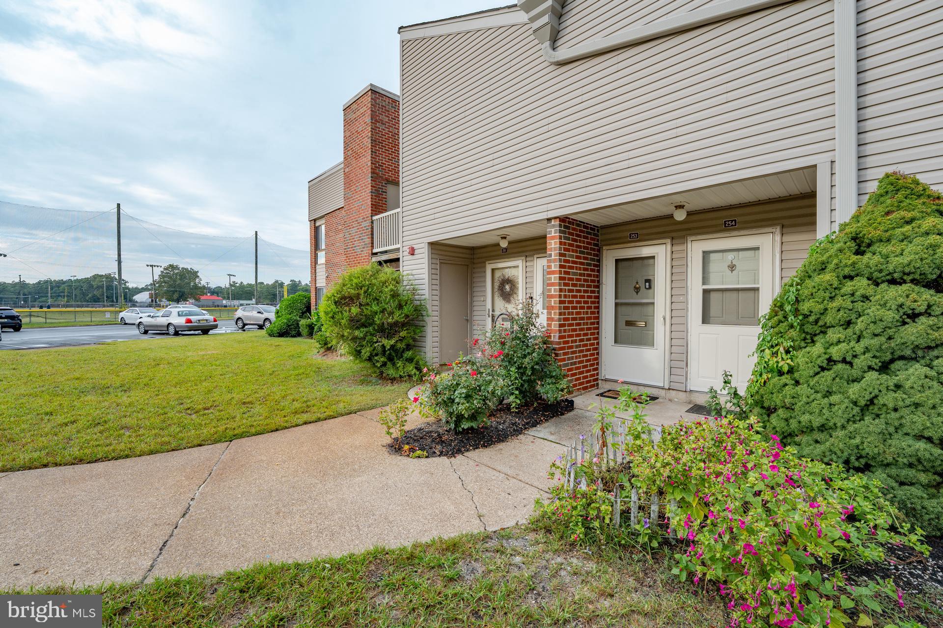254 Vail Court, Unit 1504 Mays Landing, NJ 08330 - Photo 1 of 22 a front view of a house with a yard and potted plants
