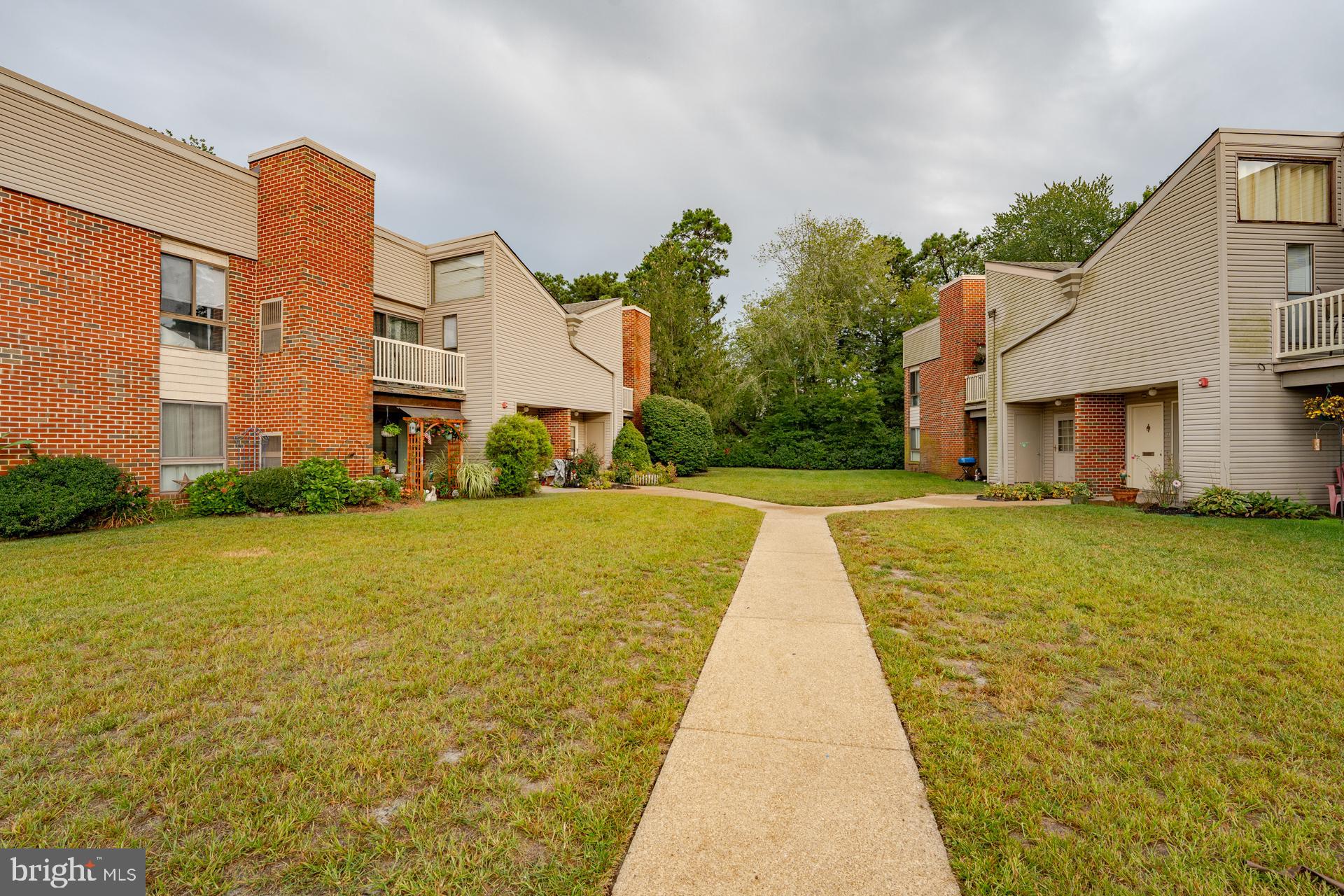 254 Vail Court, Unit 1504 Mays Landing, NJ 08330 - Photo 22 of 22 a front view of a building with a garden