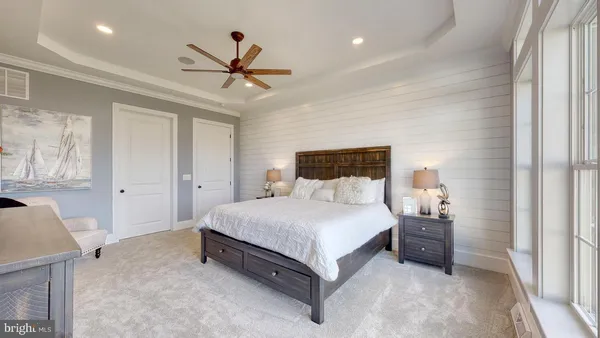 a bedroom with a bed and a ceiling fan
