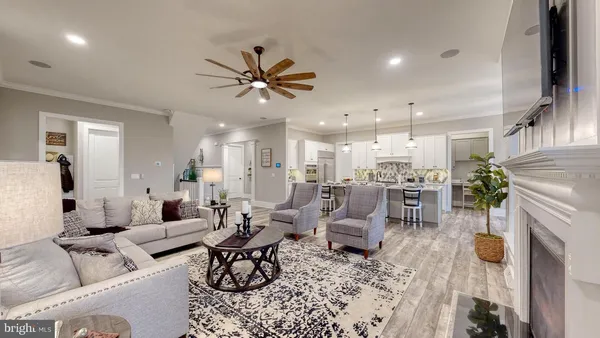 a living room with furniture and a view of kitchen