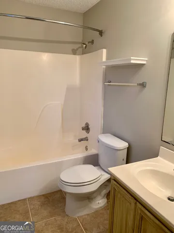 a white toilet sitting next to a bathroom sink and a shower