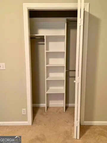 a view of walk in closet with empty racks