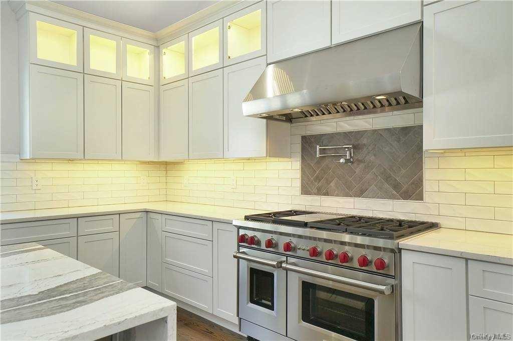 Lot 2 Wading River Road Manorville, NY 11949 - Photo 10 of 28 Kitchen featuring backsplash, exhaust hood, range with two ovens, light stone countertops, and white cabinetry. FOR MARKETING PURPOSES ONLY!