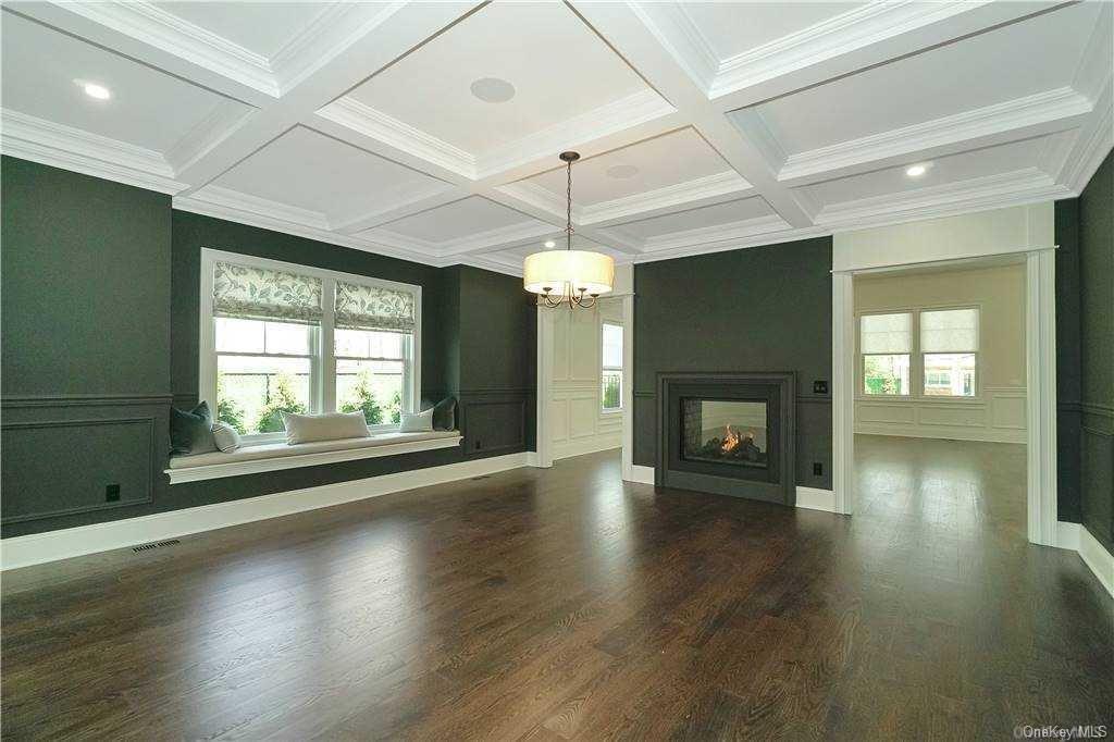 Lot 2 Wading River Road Manorville, NY 11949 - Photo 21 of 28 Unfurnished living room featuring coffered ceiling, dark wood-type flooring, crown molding, beam ceiling, and a multi sided fireplace. FOR MARKETING PURPOSES ONLY!