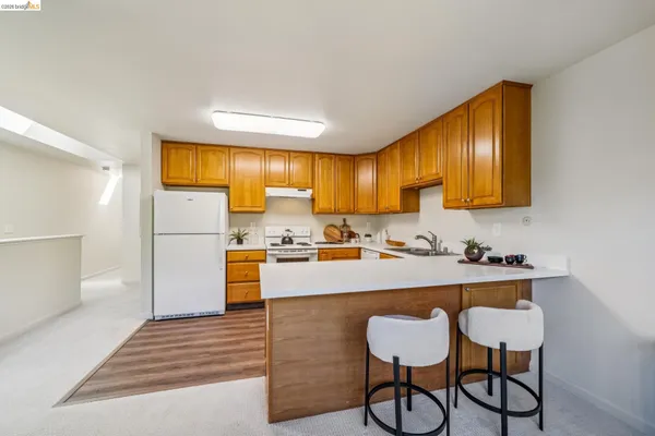 a kitchen with granite countertop wooden cabinets refrigerator and stove