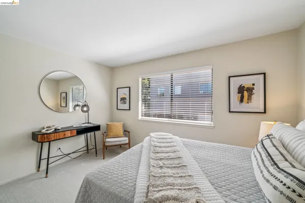 a bedroom with a bed a dresser and chair