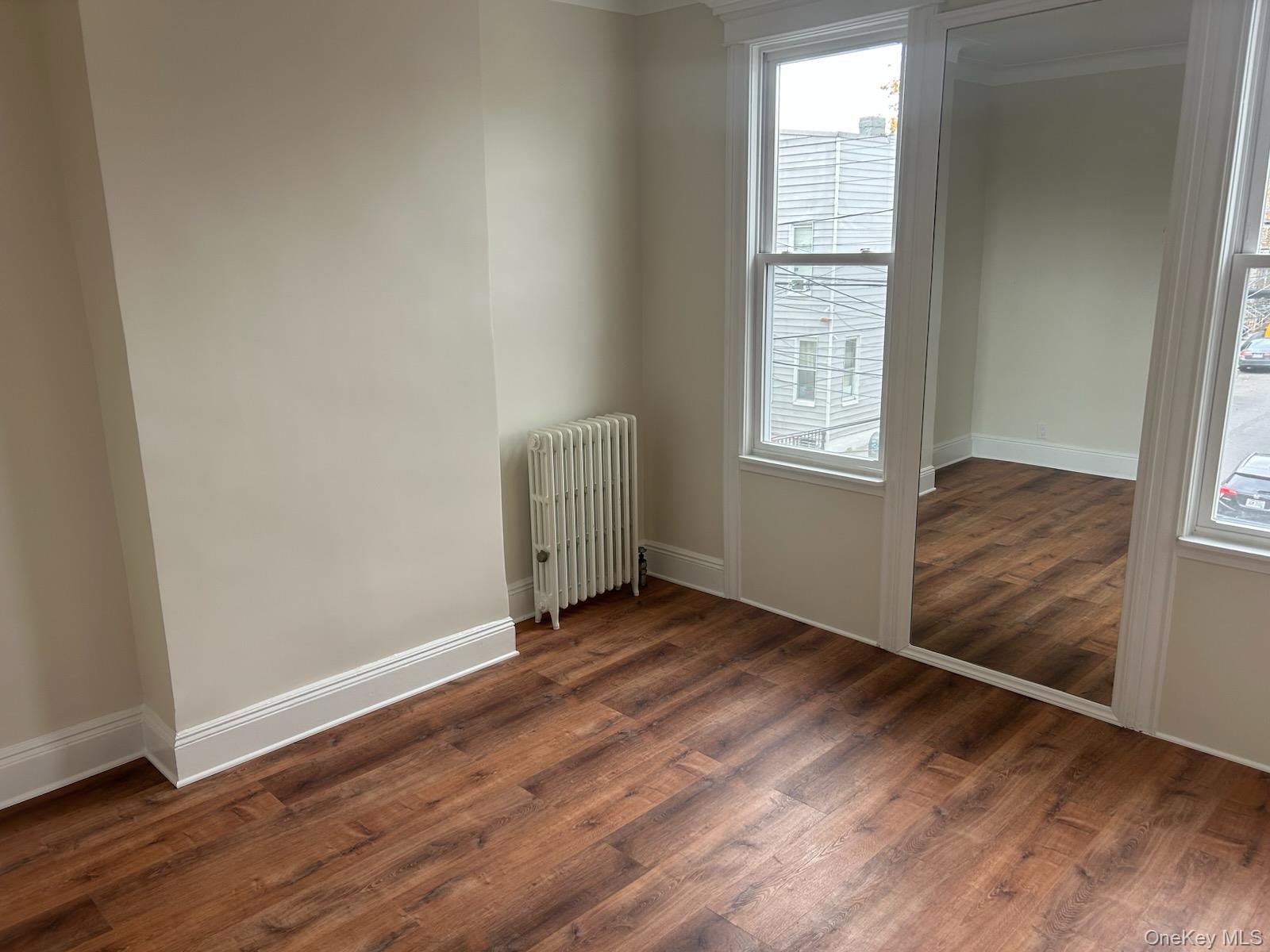 88-23 85th Street, Unit 2R Queens, NY 11421 - Photo 13 of 14 an empty room with wooden floor and windows