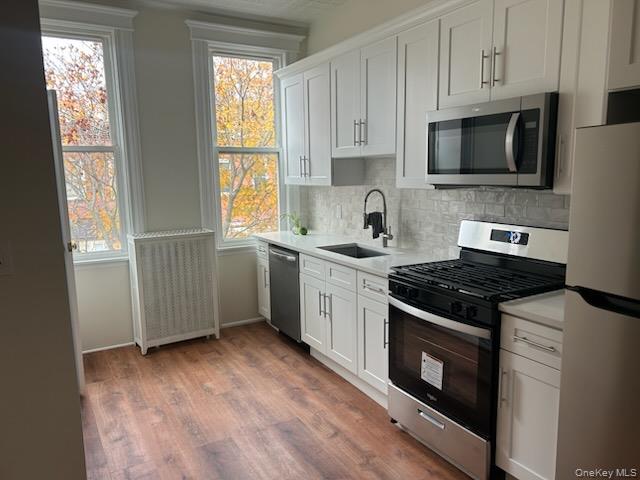 88-23 85th Street, Unit 2R Queens, NY 11421 - Photo 2 of 14 a kitchen with stainless steel appliances a stove a sink and a microwave