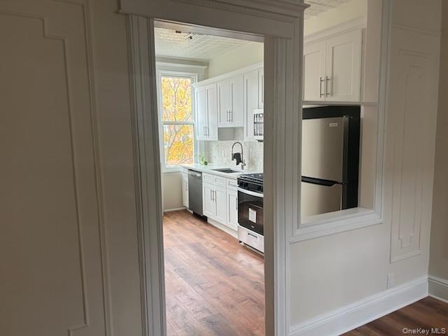 88-23 85th Street, Unit 2R Queens, NY 11421 - Photo 4 of 14 a view of a kitchen with white cabinets and refrigerator