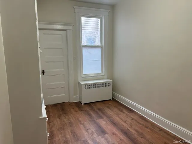 a room with a wooden floor and a window