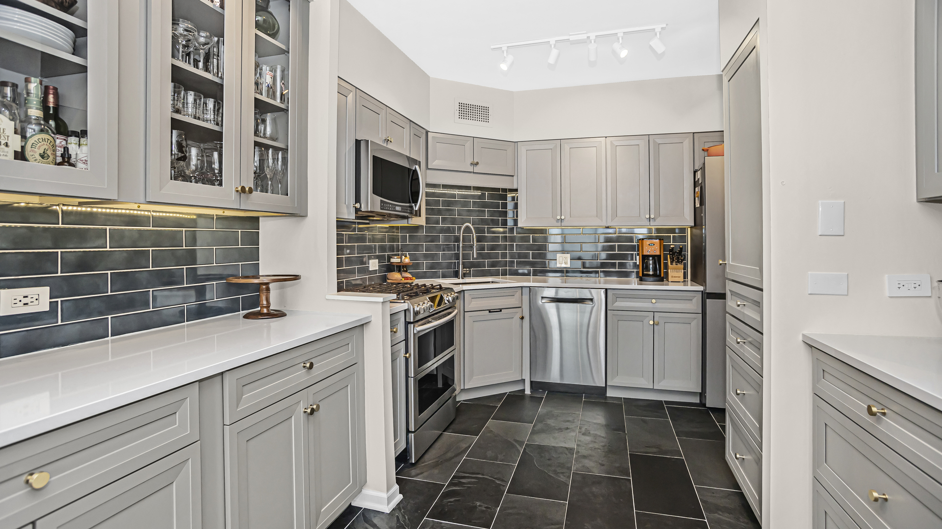 Undisclosed Address Chicago, IL 60657 - Photo 7 of 23 a kitchen with white cabinets a sink stove and refrigerator