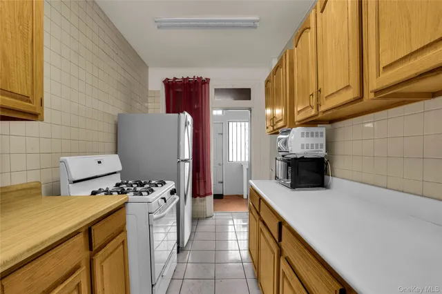 a kitchen with a stove a refrigerator and cabinets