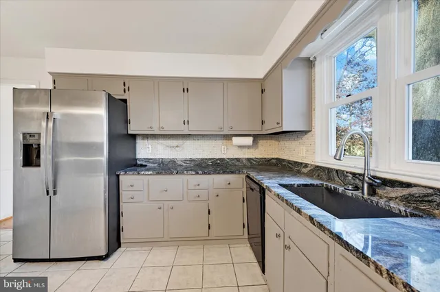 a kitchen with granite countertop a sink stove and refrigerator