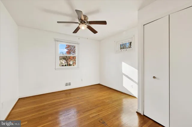 a view of empty room with wooden floor