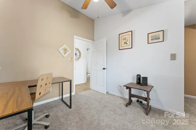 a view of a workspace with furniture and a window