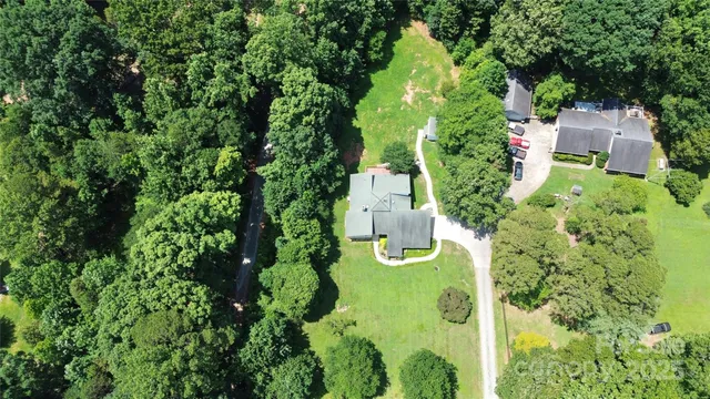 an aerial view of a house with yard swimming pool and lake view