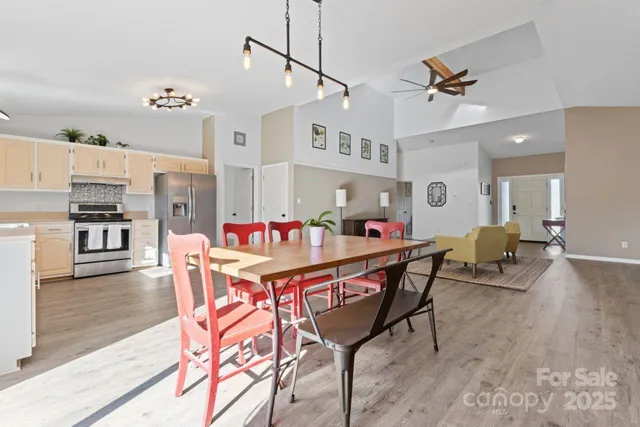 a dining room with kitchen island stainless steel appliances furniture a dining table and chairs