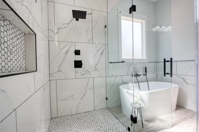 a bathroom with a granite countertop bathtub shower sink vanity and toilet