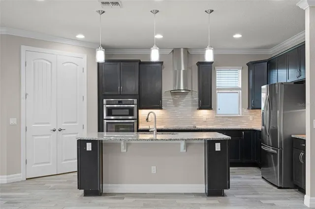 a kitchen with kitchen island stainless steel appliances a sink cabinets and refrigerator