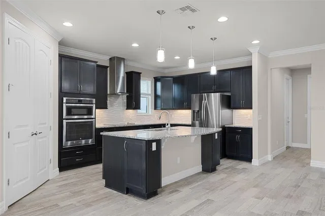 a kitchen with kitchen island stainless steel appliances cabinets and a sink