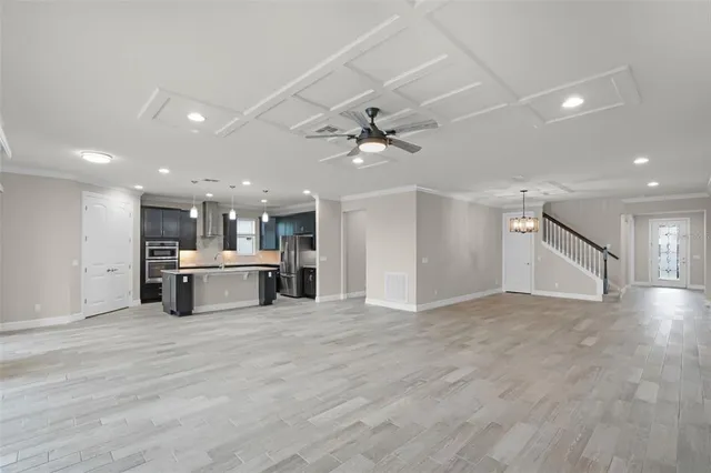 a large kitchen with kitchen island a sink stainless steel appliances and a counter space