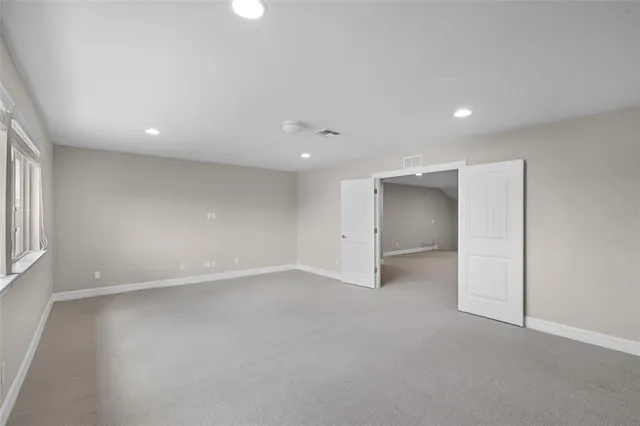 an empty room with a window and a ceiling fan