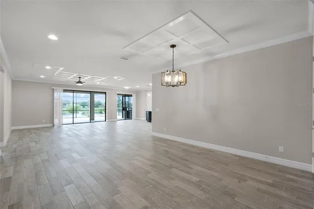 an empty room with wooden floor and window