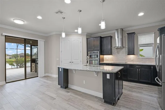 a kitchen with stainless steel appliances granite countertop a sink stove and wooden cabinets