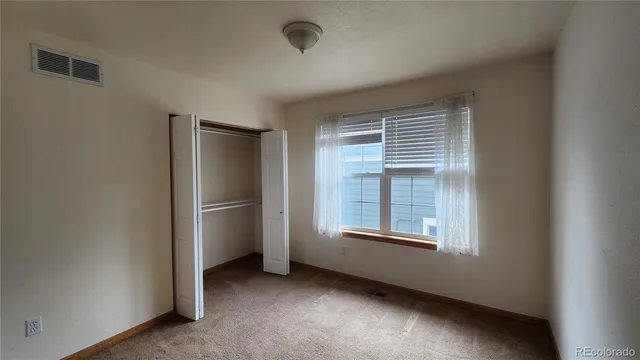 an empty room with windows and closet