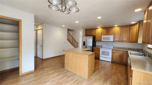 a kitchen with stainless steel appliances granite countertop wooden floors and refrigerator