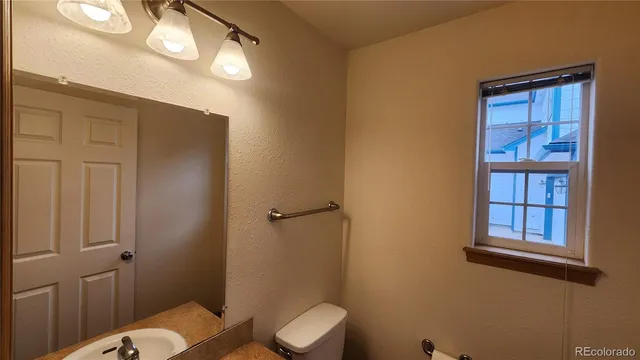 a bathroom with a toilet a sink and mirror
