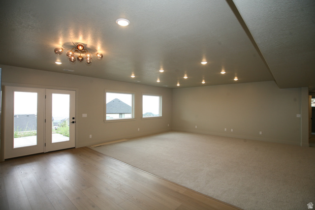 635 East Mountain Road North Ogden, UT 84414 - Photo 25 of 33 Spacious room featuring a contemporary multi-bulb ceiling fixture, multiple recessed lights, and a combination of light wood-finish flooring and neutral carpeting