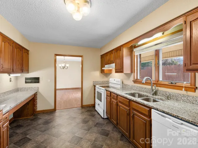 a kitchen with stainless steel appliances granite countertop a sink and a refrigerator