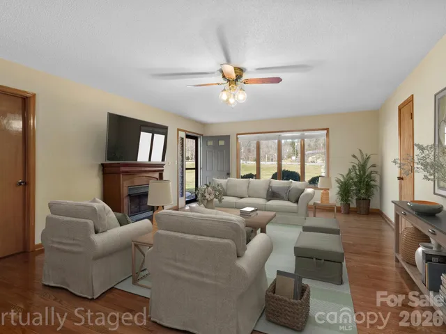 a living room with furniture a fireplace and a flat screen tv