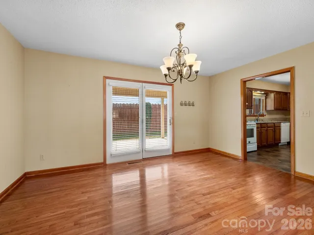 a view of a livingroom with wooden floor and a kitchen