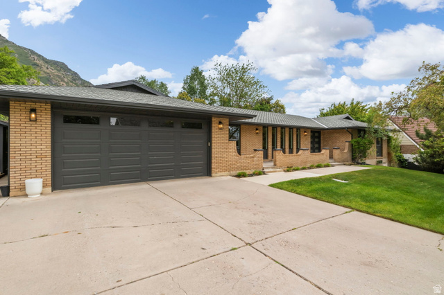 4150 Dover Lane Provo, UT 84604 - Photo 2 of 44 Brick exterior featuring a multi-car garage, concrete driveway, and front lawn