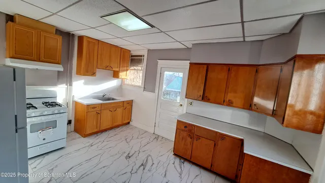 a kitchen with stainless steel appliances granite countertop a stove a sink and a refrigerator