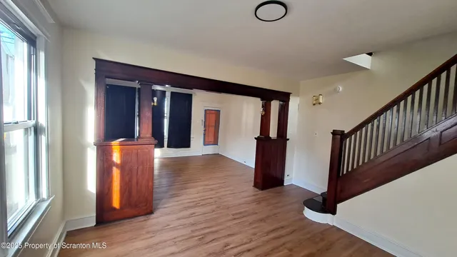 a view of a hallway with wooden floor and staircase