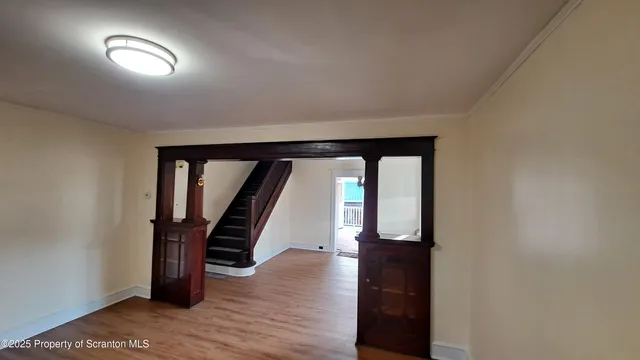 an empty room with wooden floor and stairs