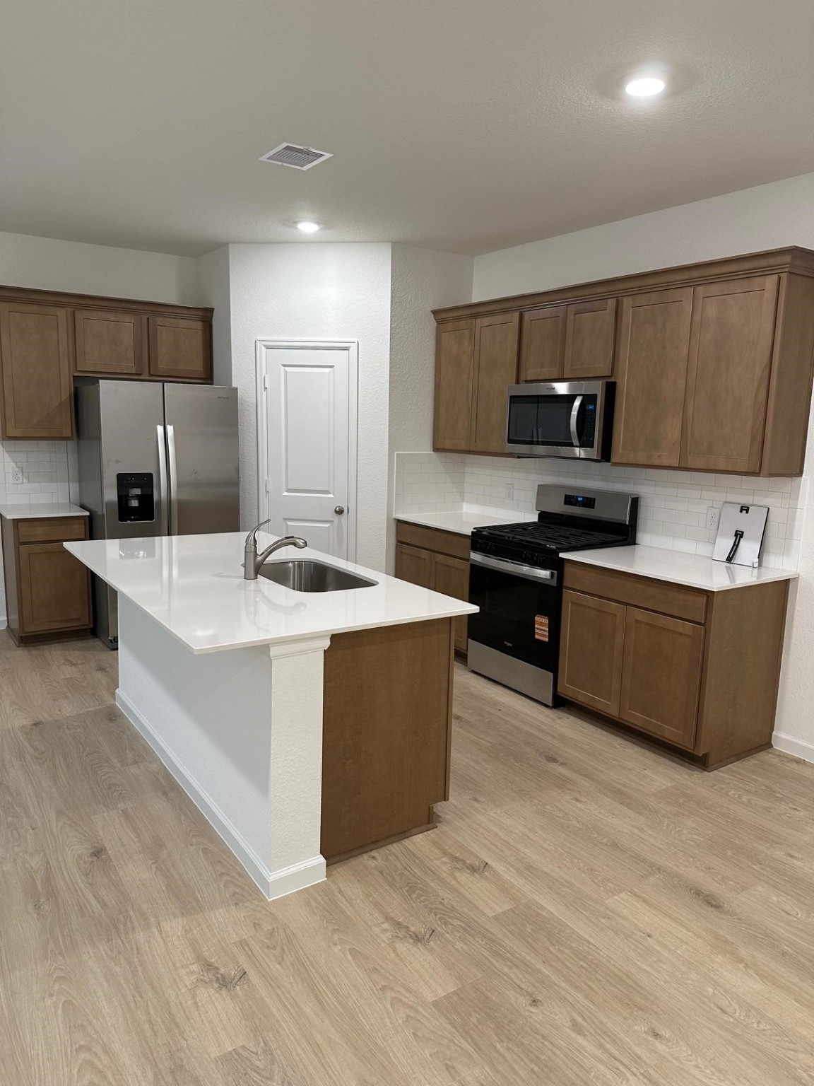 901 Coffee Ml Lane College Station, TX 77845 - Photo 4 of 18 a large kitchen with stainless steel appliances a sink a stove a refrigerator a center island and a window