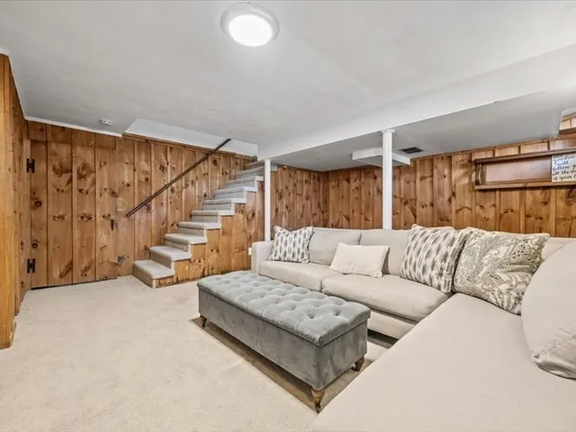 a living room with furniture a flat screen tv and a kitchen view
