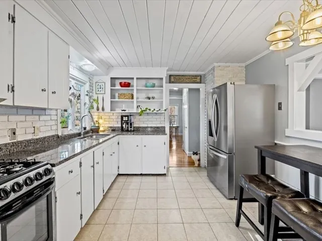 a kitchen with a refrigerator a sink and wooden cabinets